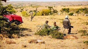 First-time safari travelers in Kidepo Valley National Park in Uganda spotting wildlife on open plains with Wild animals in backdrop.