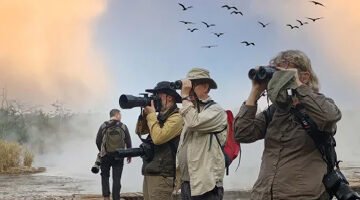 Travelers capturing wildlife in Murchison falls during a guided photo safari.